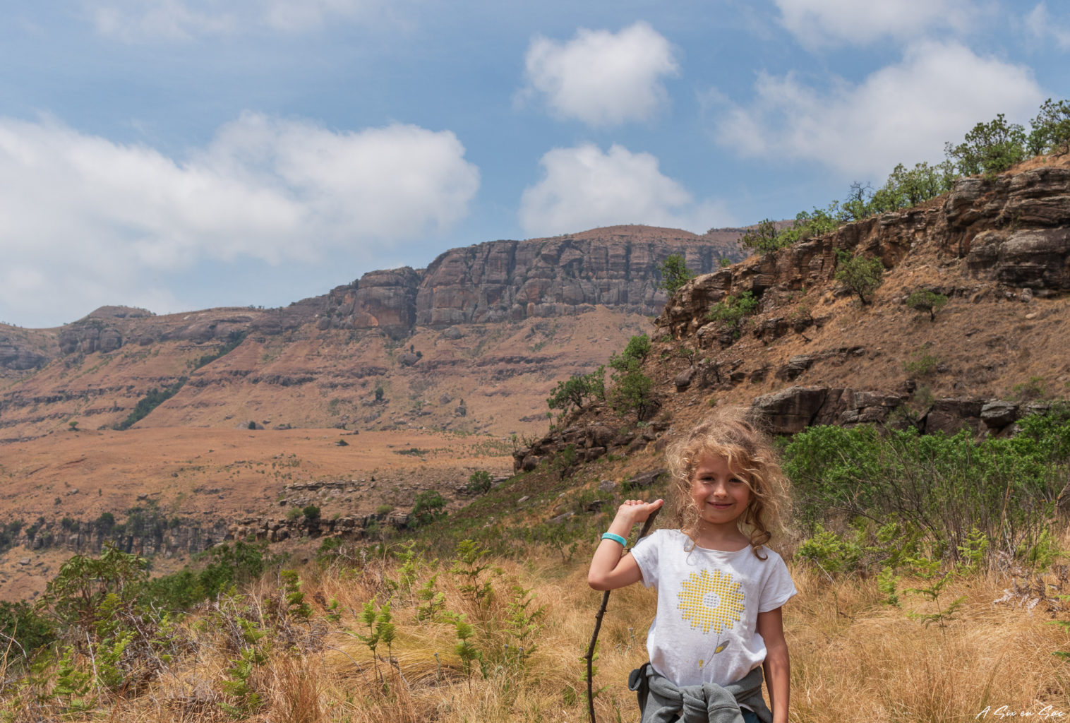 Alice toujours confiante avec en panorama la vue de la rando Grindstone Cave dans le Maloti Drakensberg Park en Afrique du Sud