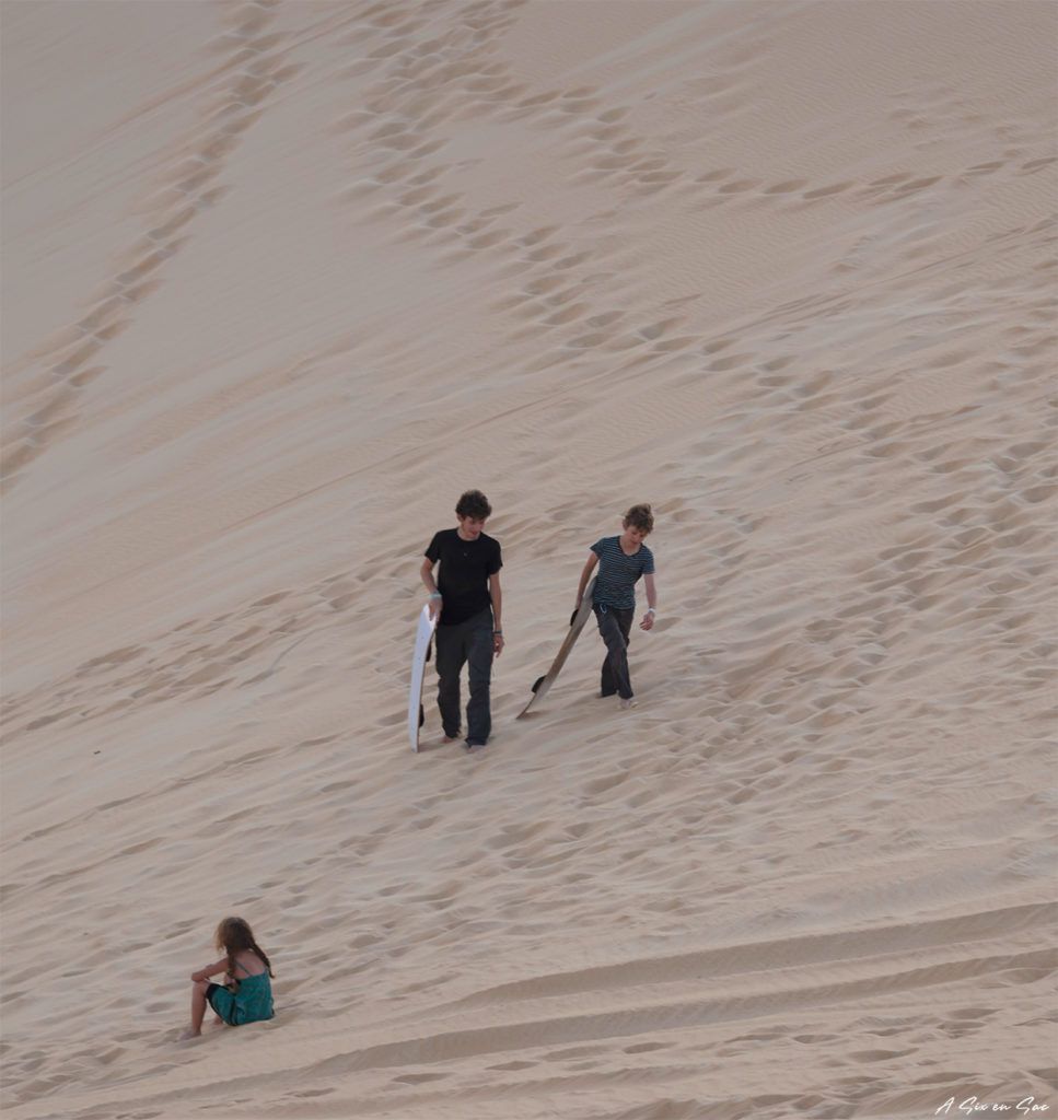 Les enfants s'essayent au sandboard dans le désert du sahara en Egypte ( excursion à la journée depuis Siwa )